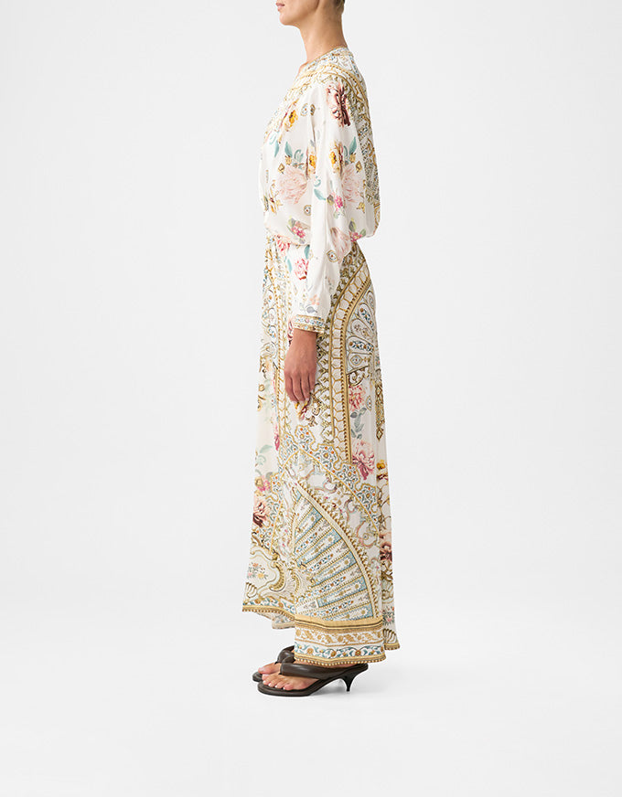 Woman wearing a floral dress with a patterned skirt on a white background. Ottoman Dynasty Twist Front Batwing Dress