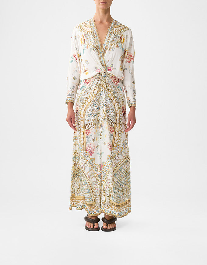 Person wearing a long, patterned dress on a white background. Ottoman Dynasty Twist Front Batwing Dress