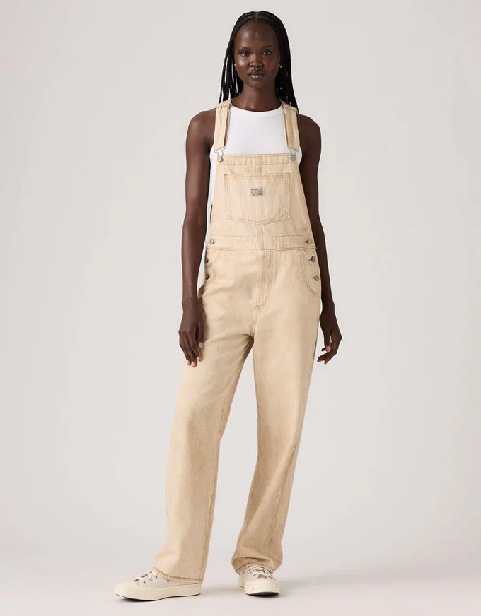 Person wearing beige overalls on a white background. Vintage Overall Cloudy Travertine