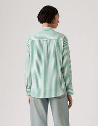 Person wearing a green and white striped shirt on a plain background