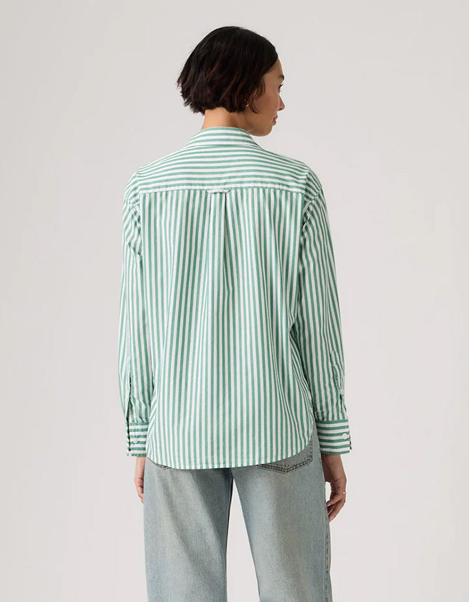 Person wearing a green and white striped shirt on a plain background