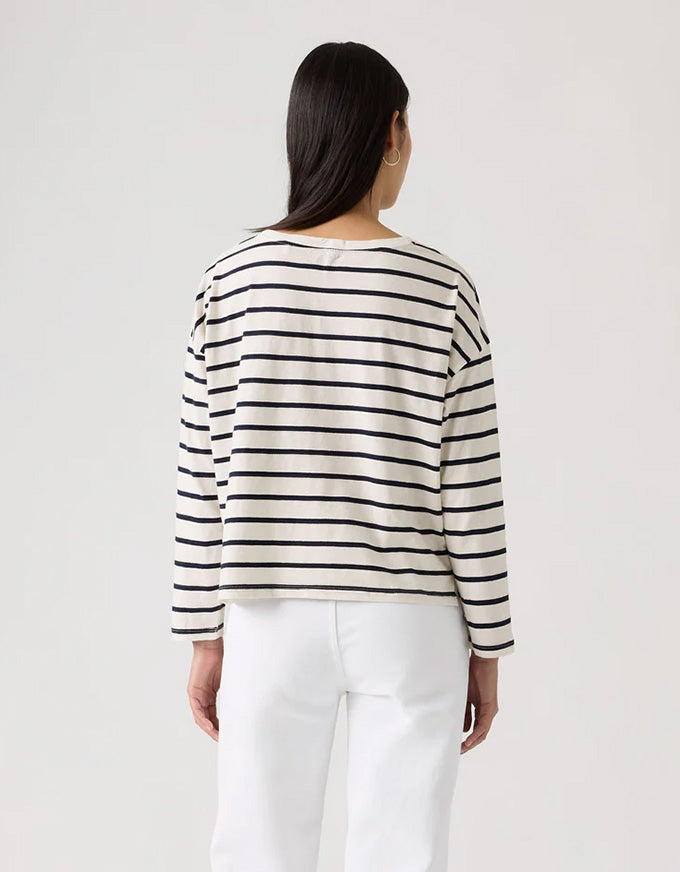 Person wearing a black and white striped sweater against a plain background