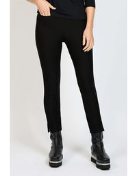 Person wearing black pants and black boots on a white background