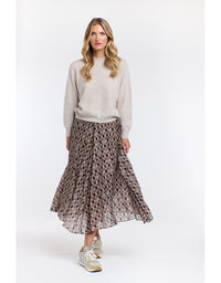 Woman wearing a patterned skirt and light sweater on a white background