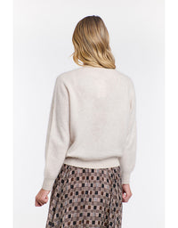 Woman wearing a beige sweater and plaid skirt on a white background