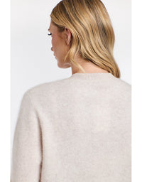 Woman wearing a beige sweater on a white background