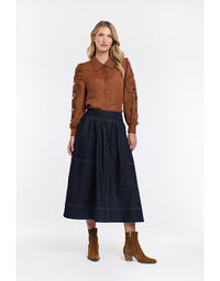 Woman wearing a brown blouse and black skirt on a white background