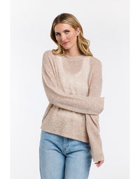 Woman wearing a beige sweater and blue jeans on a white background