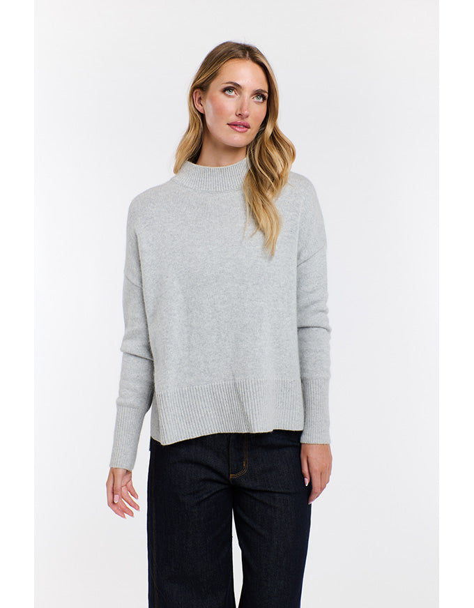 Woman wearing a gray sweater on a white background