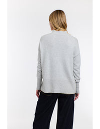 Person wearing a light gray sweater on a white background
