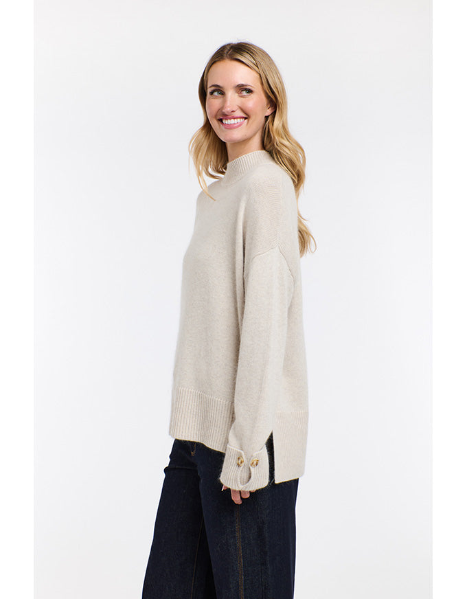 Woman wearing a beige sweater on a white background