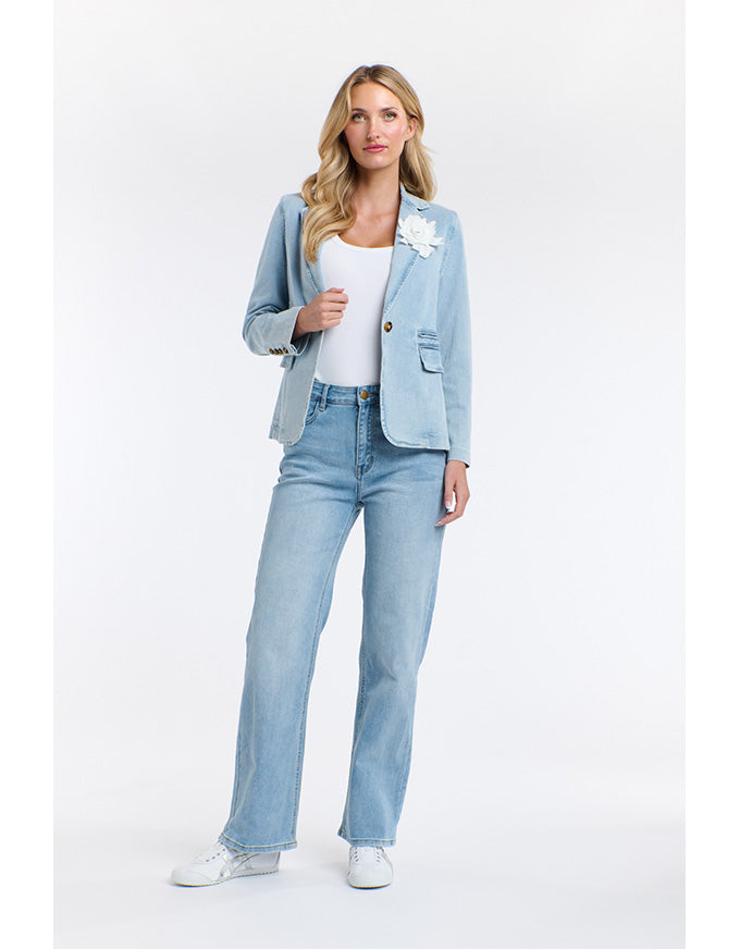 Woman wearing a light blue blazer and jeans on a white background
