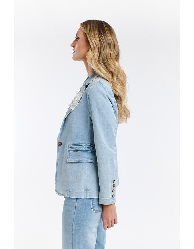 Woman wearing a light blue denim jacket on a white background