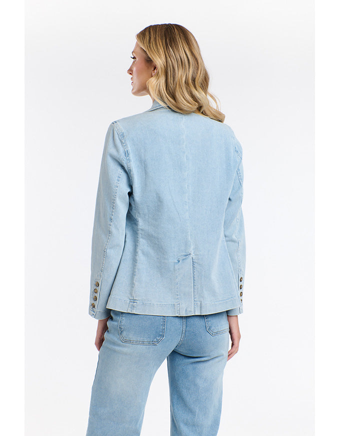 Woman wearing a light blue denim jacket and jeans on a white background