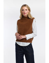 Woman wearing a brown vest over a white shirt with a plain background