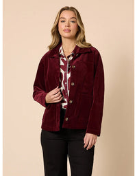 Woman wearing a burgundy jacket with a beige background