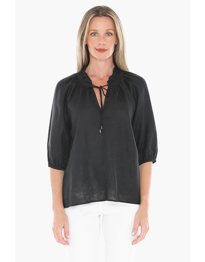 Woman wearing a black blouse with lace-up details on a white background