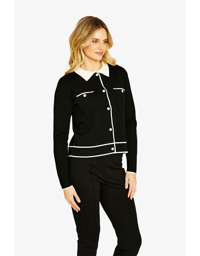 Woman wearing a black and white outfit with a white collar on a white background