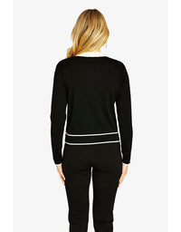 Woman wearing a black outfit with white trim on a white background