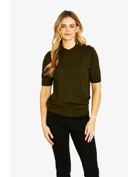 Woman wearing a dark green sweater and black pants on a white background