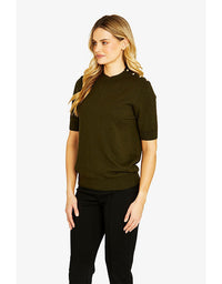 Woman wearing an olive green sweater and black pants on a white background