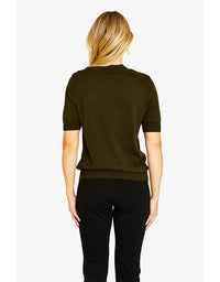 Person wearing a green sweater and black pants on a white background