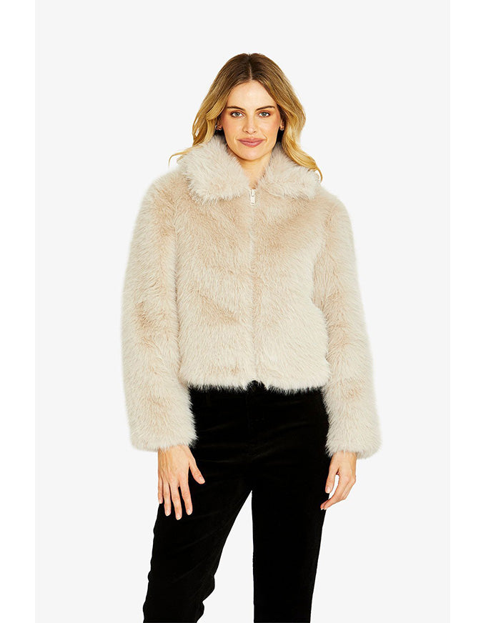 Woman wearing a beige fur coat on a white background