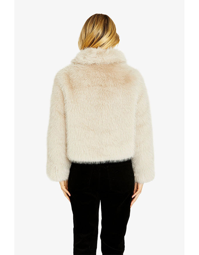 Person wearing a fluffy beige jacket on a white background