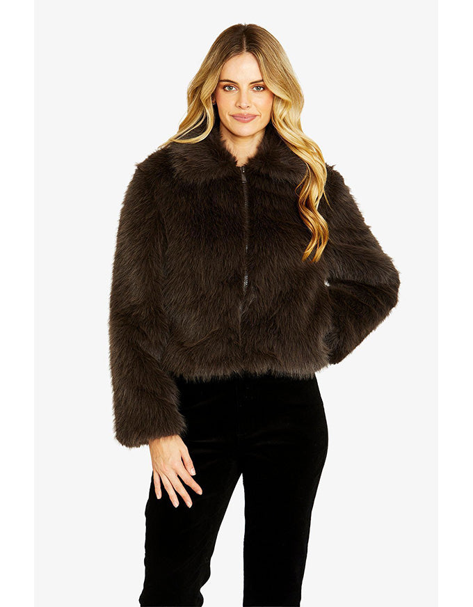 Woman wearing a brown faux fur jacket on a white background