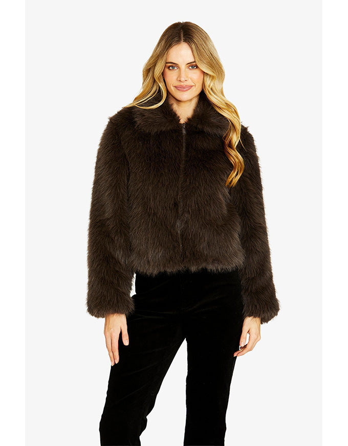 Woman wearing a brown faux fur jacket on a white background