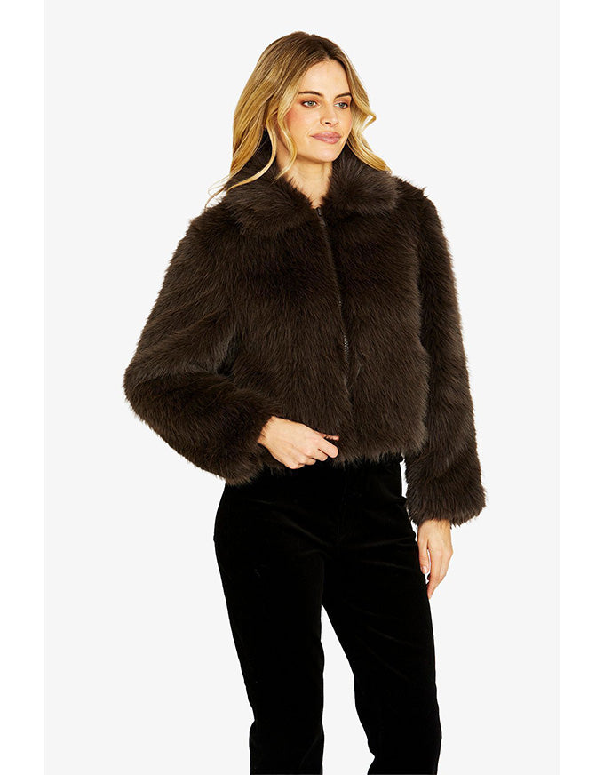 Woman wearing a brown faux fur jacket on a white background