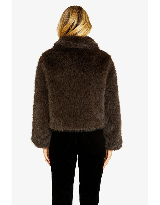 Brown fur jacket worn by a person on a white background