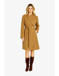 Woman wearing a brown coat and brown boots on a white background