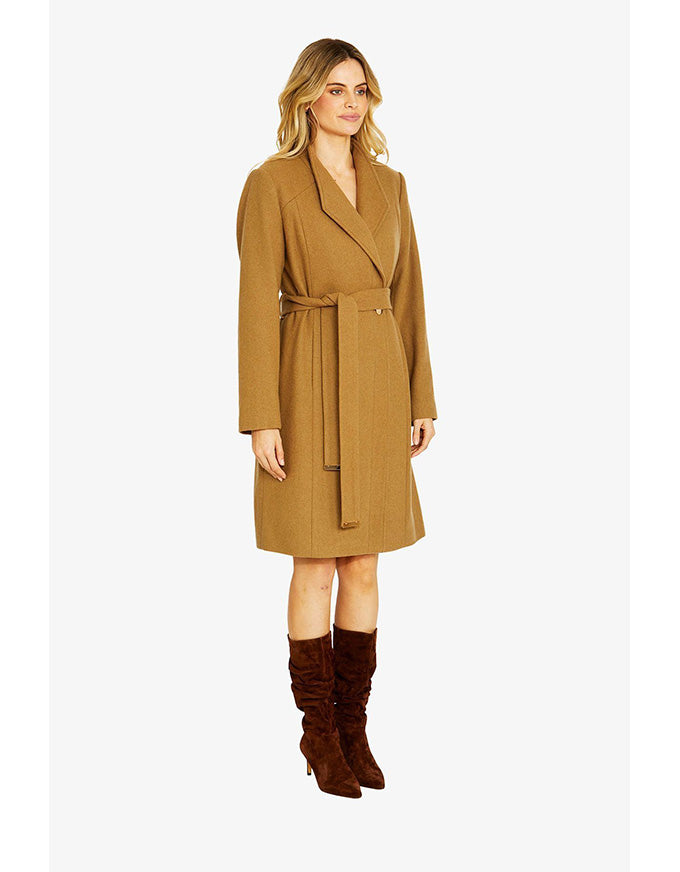 Woman wearing a brown coat and brown boots on a white background