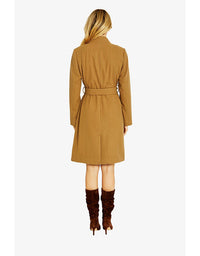 Woman wearing a brown coat and brown boots on a white background