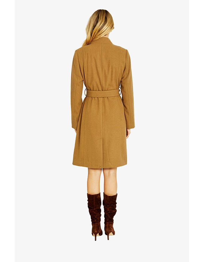 Woman wearing a brown coat and brown boots on a white background
