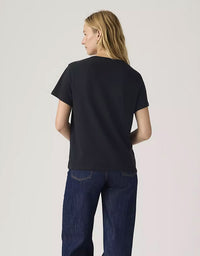 Person wearing a black t-shirt and blue jeans on a light gray background