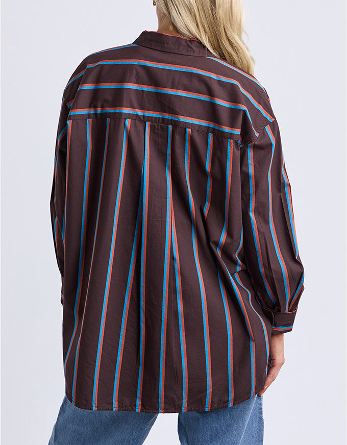 Person wearing a brown striped shirt with blue and red lines on a white background