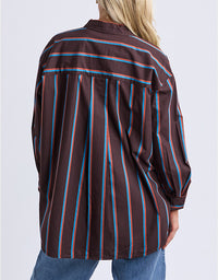 Person wearing a brown striped shirt with blue and red lines on a white background