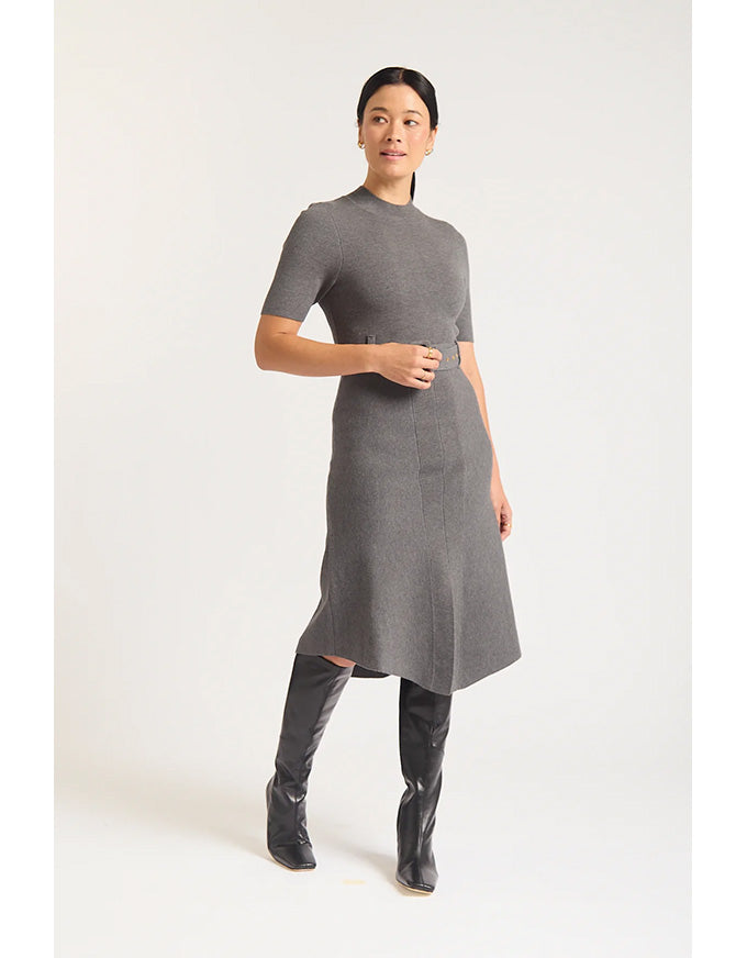 Woman wearing a gray dress with short sleeves and a slit, standing against a white background.