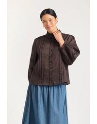 Woman wearing a brown blouse and blue skirt on a white background