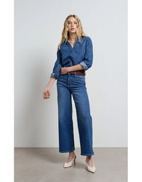 Woman wearing a blue denim outfit on a plain background