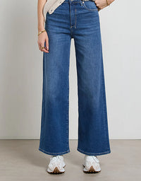Person wearing blue wide-leg jeans on a plain background