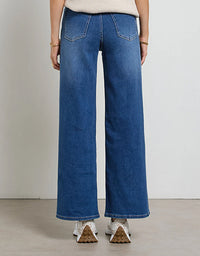Person wearing blue wide-leg jeans on a plain background