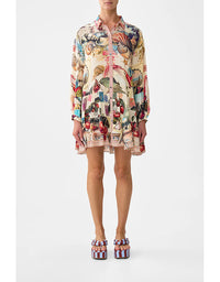 Person wearing a colorful patterned dress on a white background. Notes From The Road L/S Tiered Short Dress