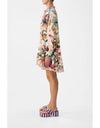 Woman wearing a colorful floral dress on a white background. Notes From The Road L/S Tiered Short Dress