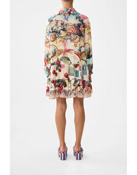 Person wearing a colorful dress with a pattern of seashells, fish, and other sea-themed elements on a white background. Notes From The Road L/S Tiered Short Dress