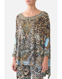 Woman wearing a patterned dress with leopard print and floral design on a white background