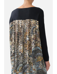 Person wearing a black top with a multicolored patterned skirt on a white background