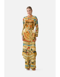 Woman wearing a colorful patterned outfit on a white background